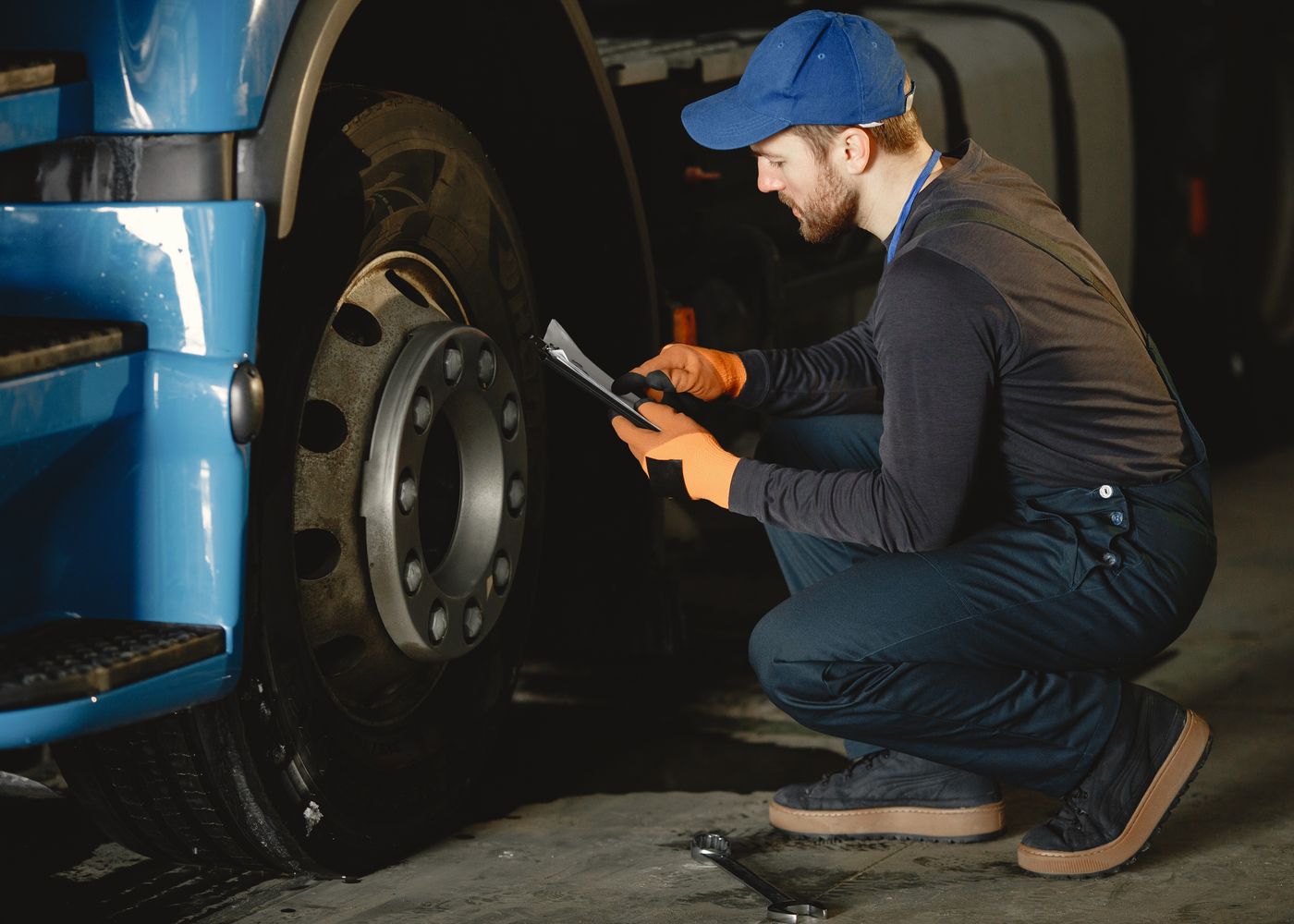 Truck inspection checklist: technician reviewing wheel condition. Illustrative stock photo.