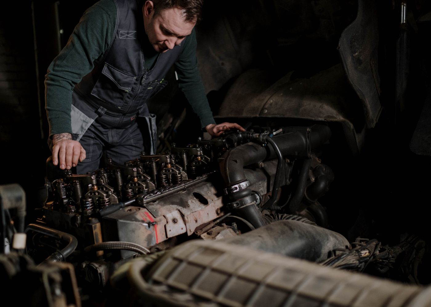 SHACMAN specifications: mechanic working on truck engine. Illustrative stock photo.